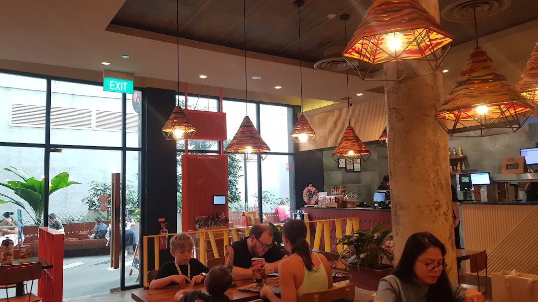 Interior of Nandos restaurant with customers dining and a view of the outdoor area.