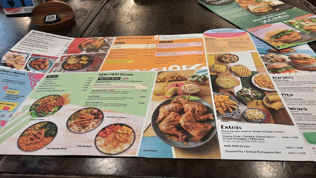 A detailed Nando's menu displaying various PERi-PERi chicken dishes, bowls, sides, and more.