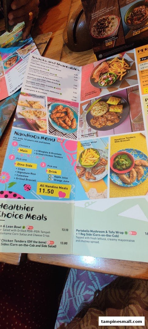 A close-up view of Nandos' in-restaurant menu, displaying various food categories and prices.
