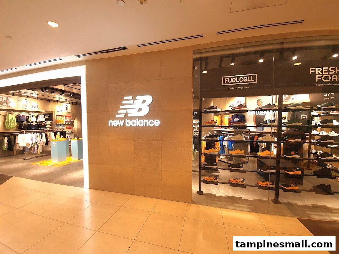 The New Balance store entrance featuring its prominent logo and a vibrant display of athletic footwear and apparel.