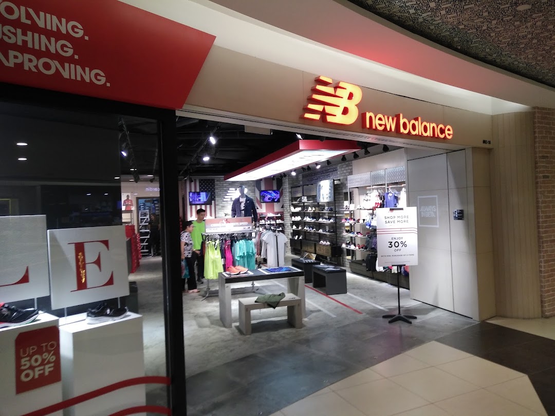 The New Balance store entrance showcasing athletic footwear, apparel, and current promotions.