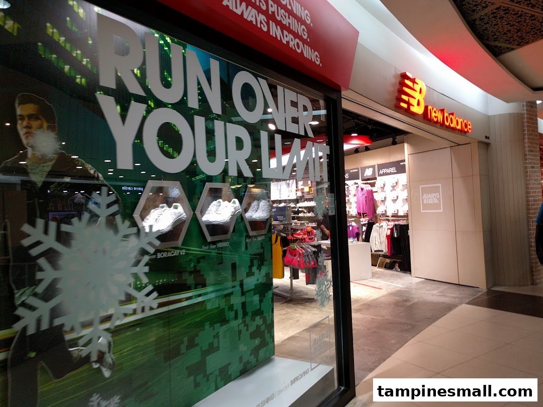 The New Balance shop front features a dynamic window display with shoes and apparel, inviting customers inside.