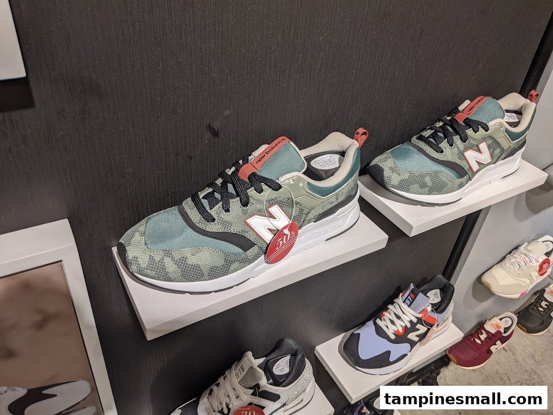 New Balance sneakers displayed on shelves, showcasing various styles and colors in a retail setting.
