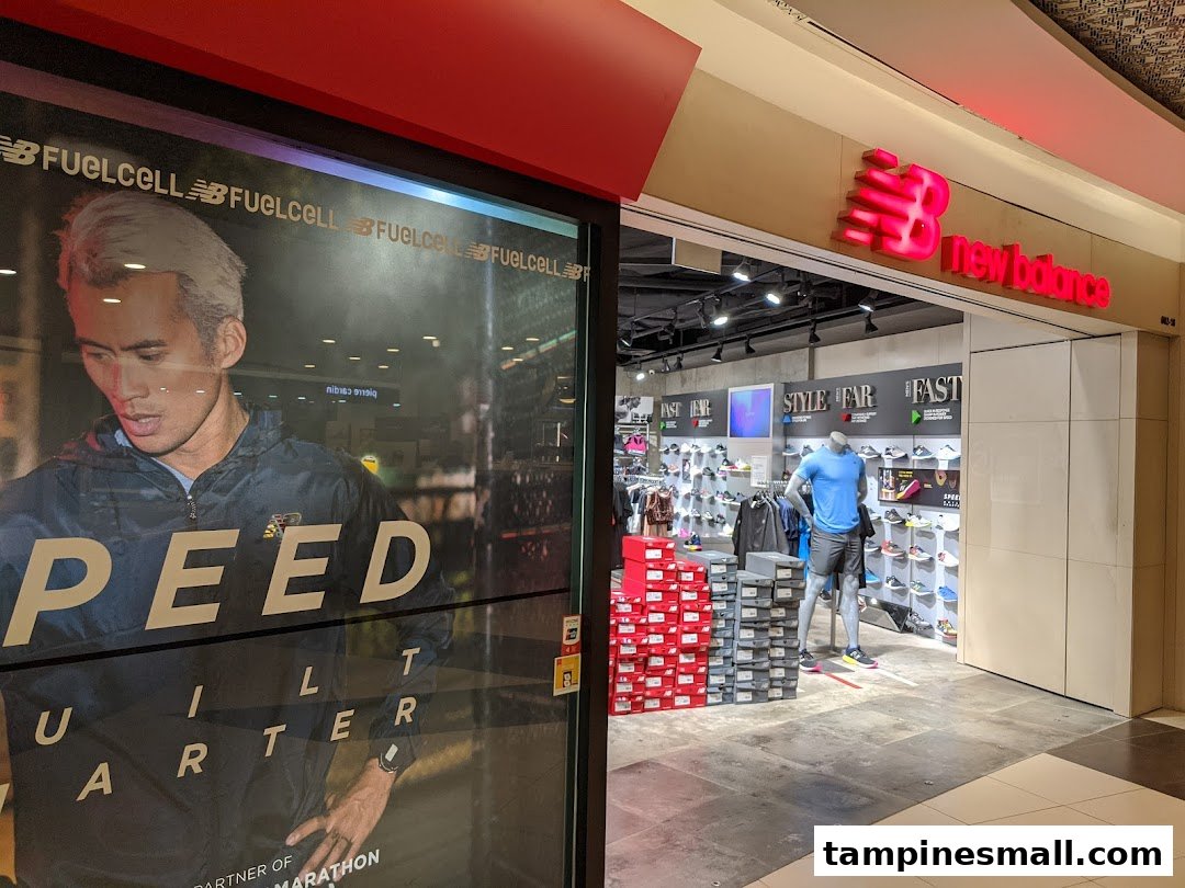 The New Balance store entrance features a large promotional poster and an inviting view of athletic footwear and apparel.