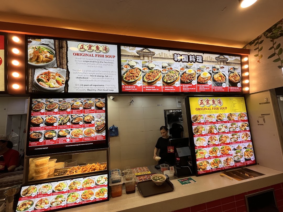 A bustling food stall featuring diverse menu boards for fish soup and Korean cuisine.