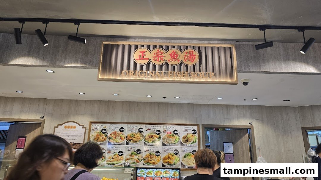 A bustling food stall featuring a large menu board with various fish soup and porridge dishes.