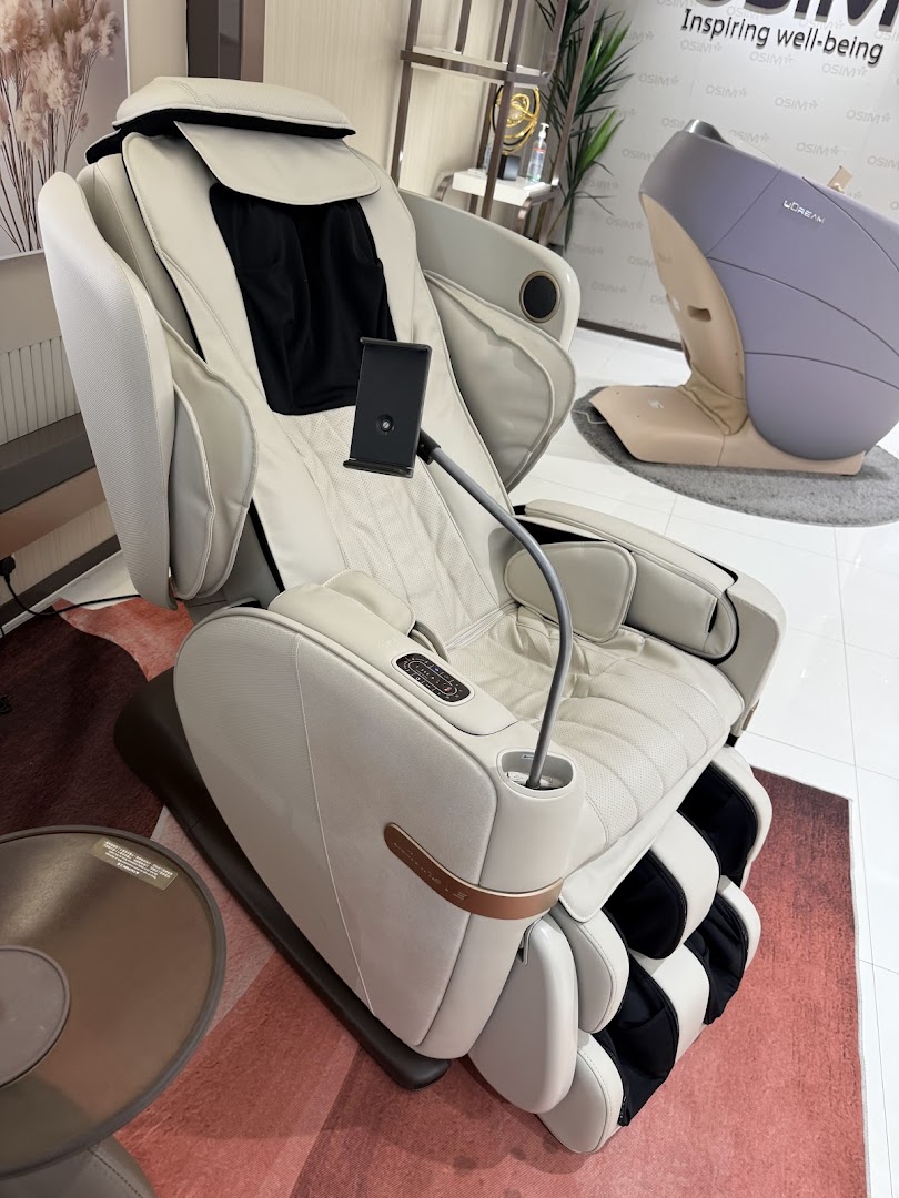 A luxurious cream-colored OSIM massage chair with a phone holder, showcasing comfort and wellness technology.