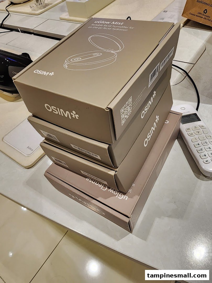 A stack of OSIM uGlow Mist and uGlow Cleanse product boxes on a counter.