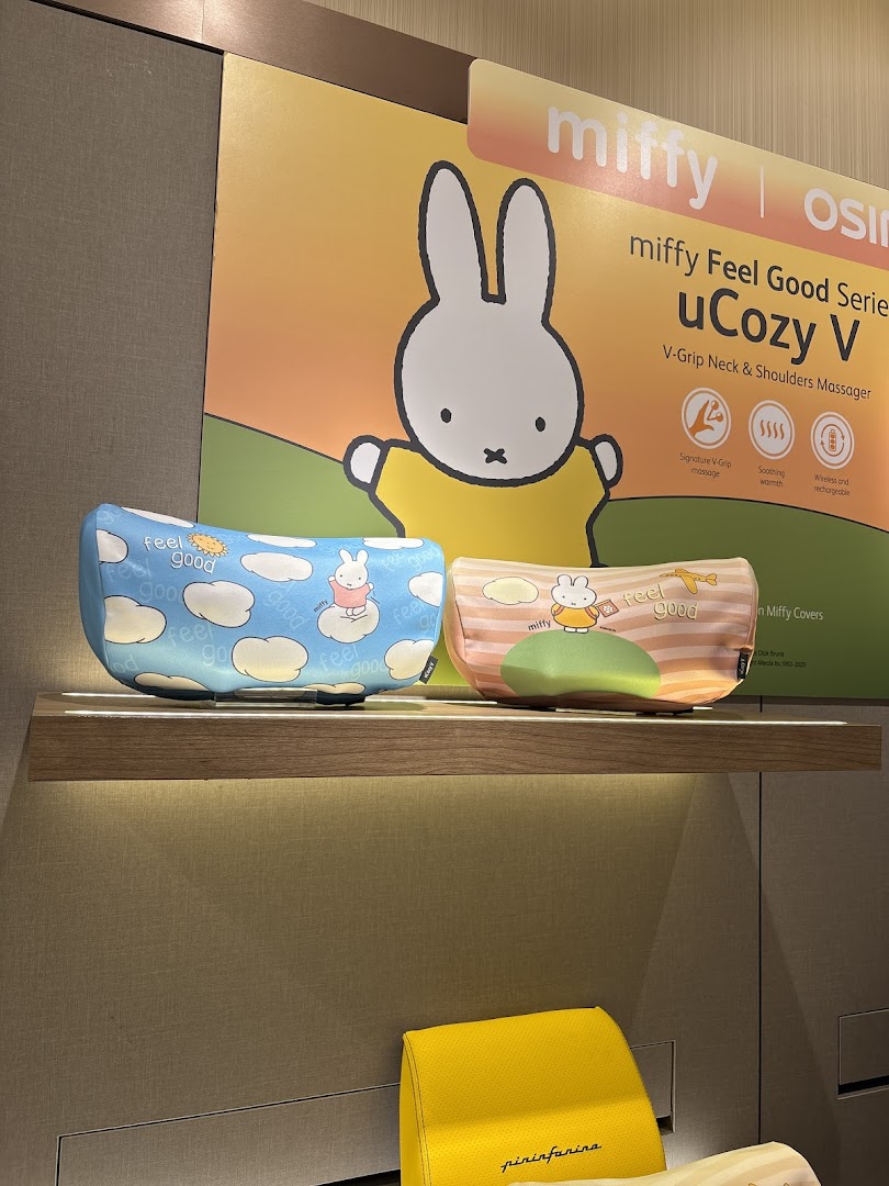 Miffy-themed uCozy V neck and shoulder massagers displayed on a lighted shelf with a promotional poster.