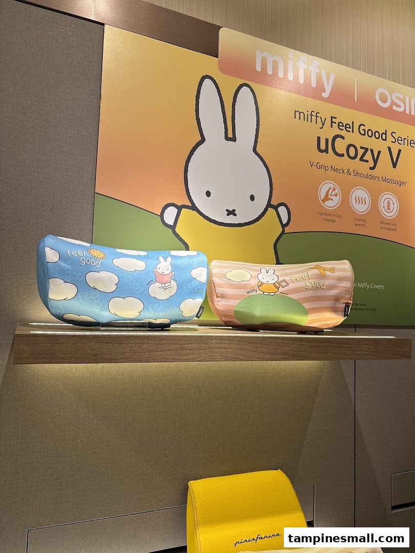Miffy-themed uCozy V neck and shoulder massagers displayed on a lighted shelf with a promotional poster.