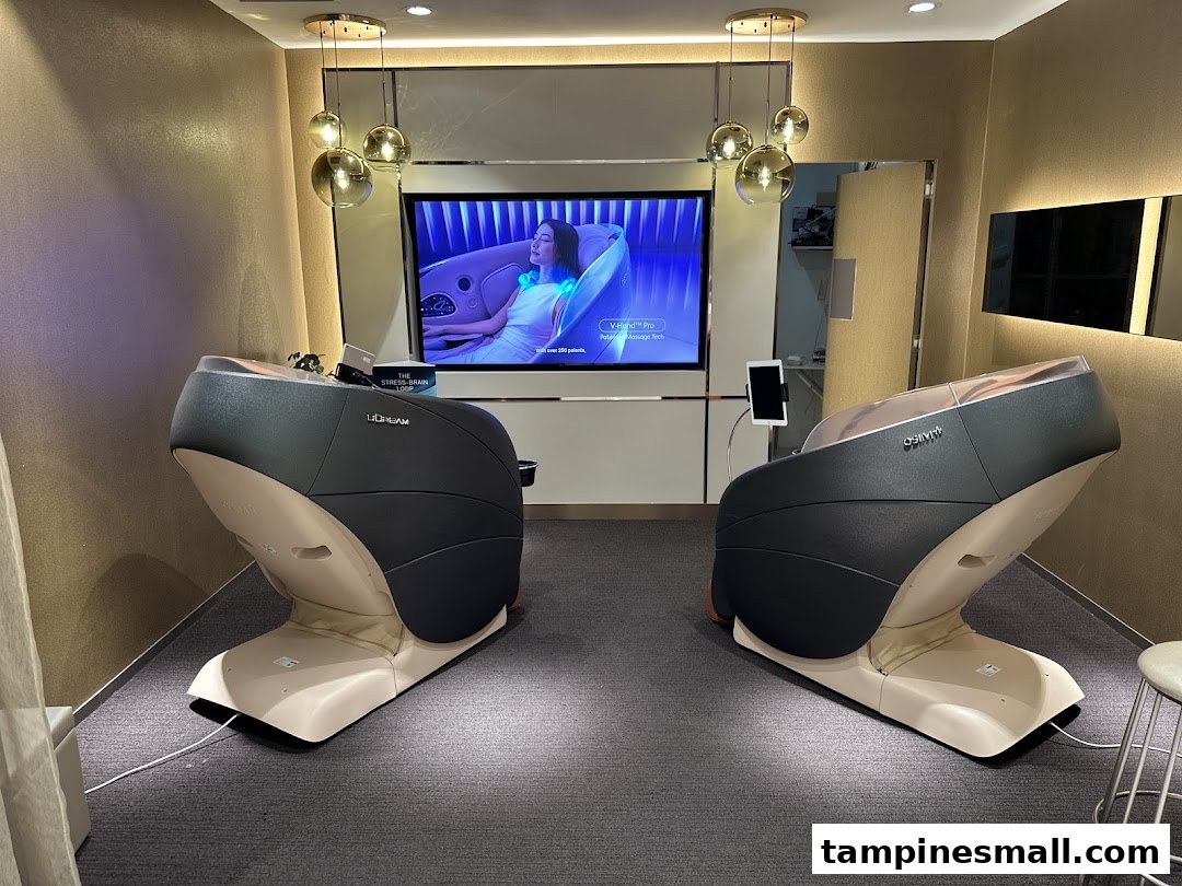 Two modern OSIM massage chairs displayed in a showroom with a large screen showcasing product features.