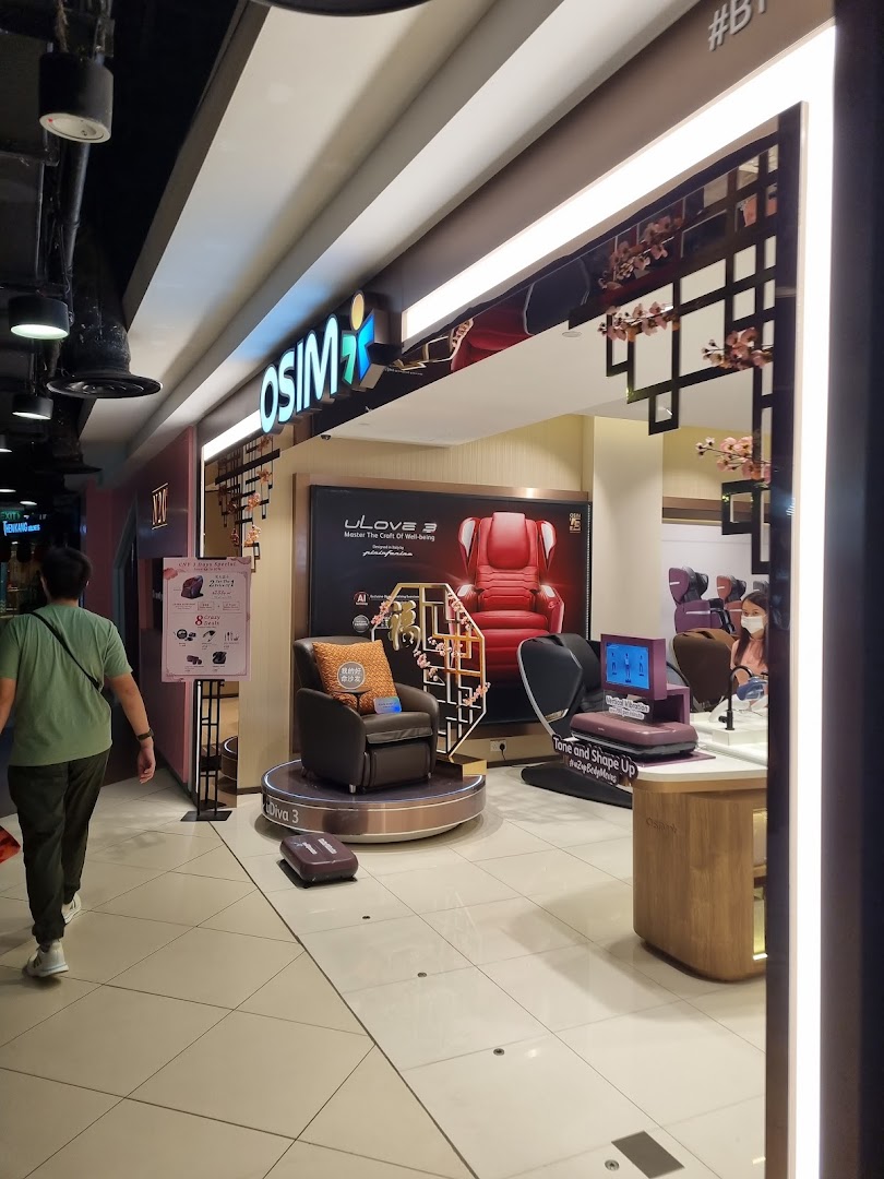 The OSIM shop entrance featuring massage chairs and wellness products, with a shopper walking past.