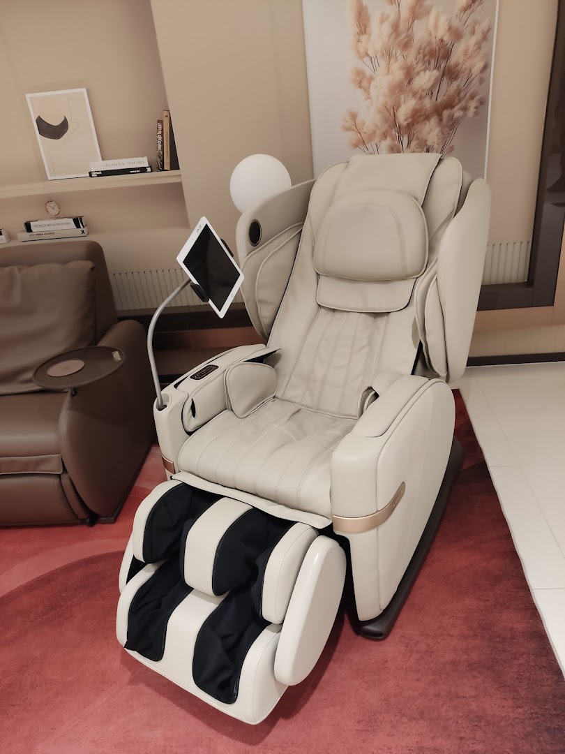 A luxurious beige OSIM massage chair with an attached tablet stand, displayed in a modern showroom.