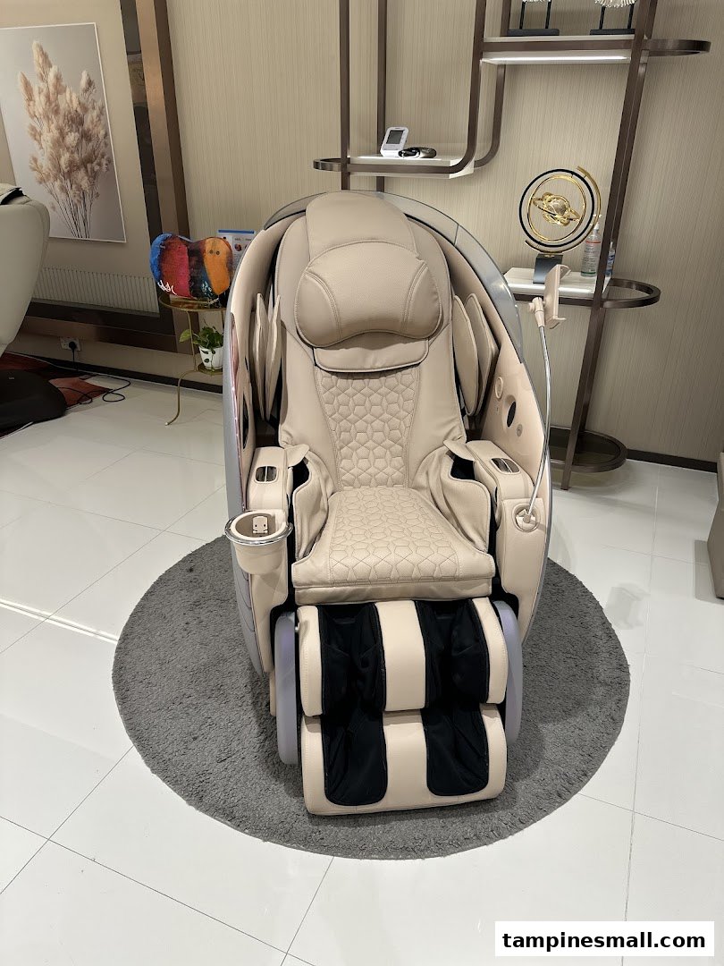 A luxurious beige massage chair with intricate patterns sits on a grey rug in a modern showroom.