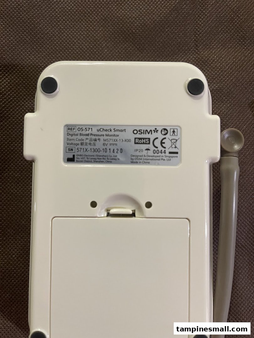 The back of an OSIM uCheck Smart Digital Blood Pressure Monitor, displaying product specifications and manufacturing details.