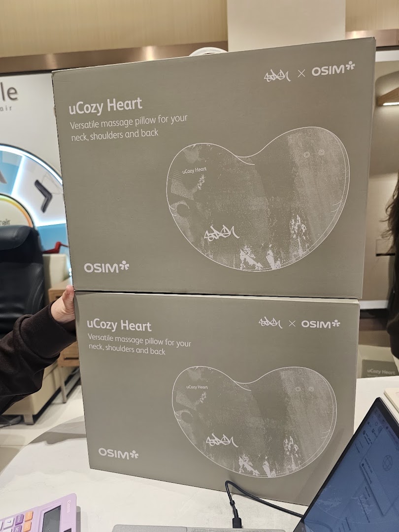 Two OSIM uCozy Heart massage pillow boxes are stacked, showcasing versatile comfort for neck, shoulders, and back.