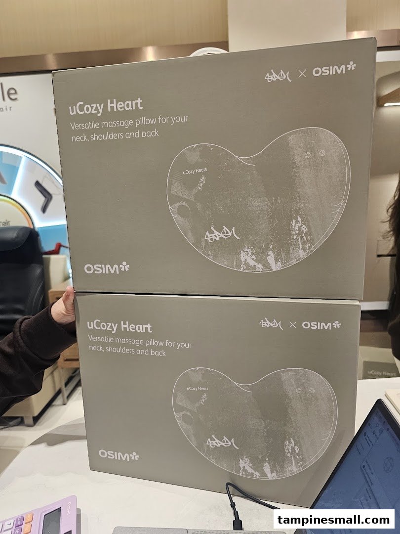 Two OSIM uCozy Heart massage pillow boxes are stacked, showcasing versatile comfort for neck, shoulders, and back.