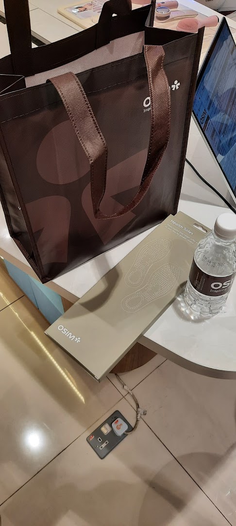 An OSIM shopping bag, Health Soles product, and branded water bottle on a display table inside the shop.