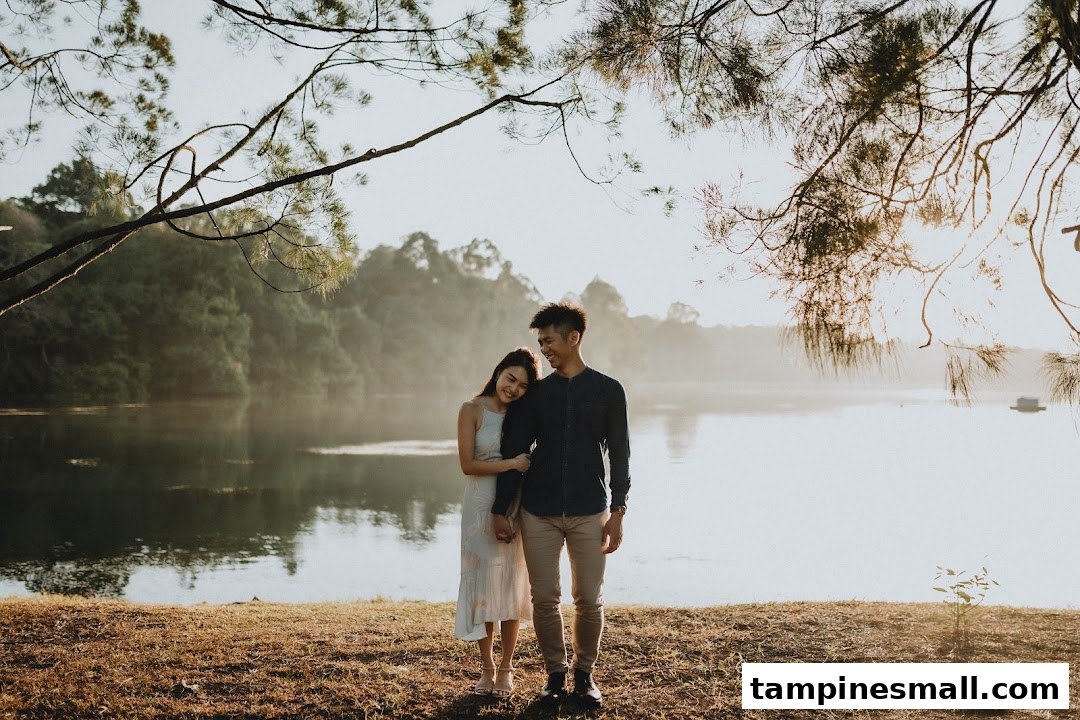 A loving couple stands by a serene lake at sunrise, captured beautifully for their wedding story.