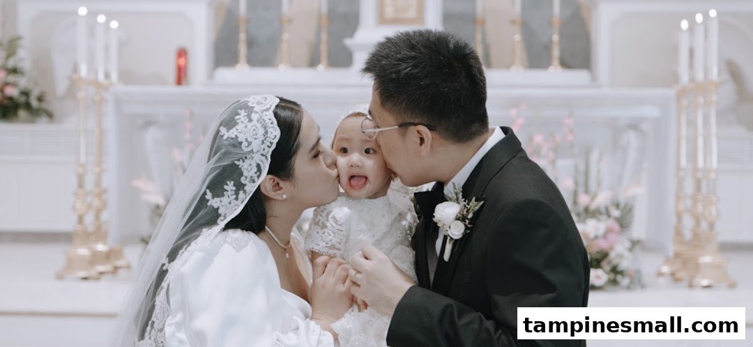 A couple in wedding attire lovingly kisses a baby in a beautiful church setting, capturing a tender family moment.
