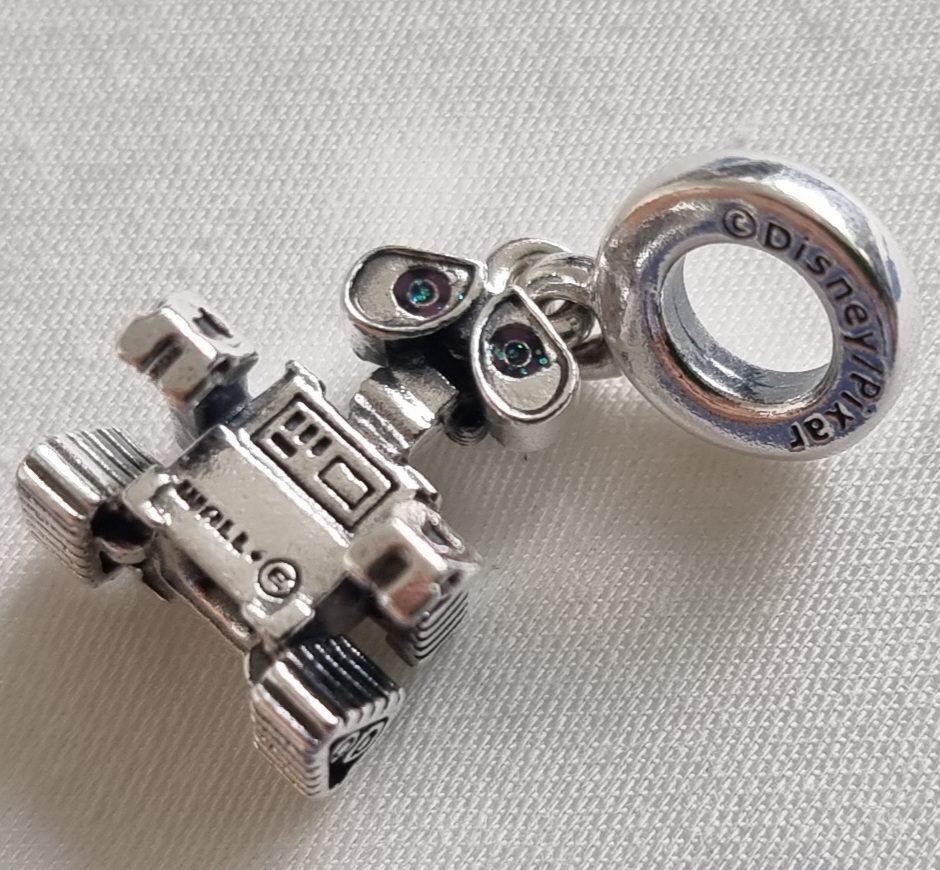 A close-up of a silver Pandora charm featuring the Disney/Pixar character WALL-E, with 'Disney/Pixar' engraved.