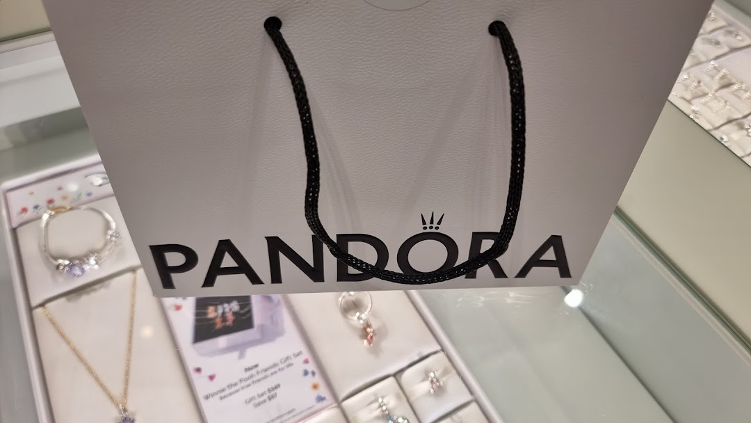 A Pandora shopping bag prominently displayed amidst jewelry in a retail store.