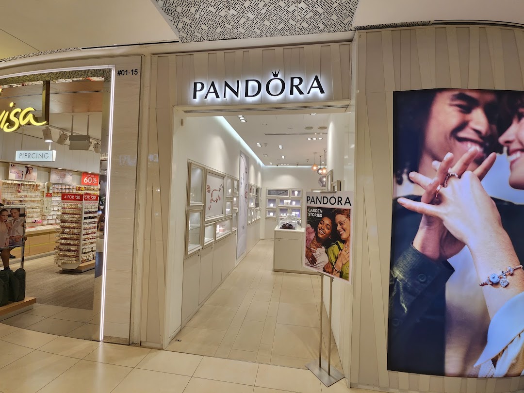 The brightly lit entrance of a Pandora jewelry store, showcasing its inviting interior and branding.