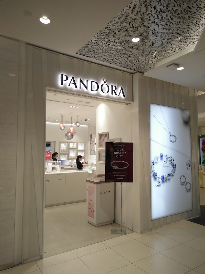 The brightly lit entrance of a Pandora jewelry store showcasing its elegant interior and displays.