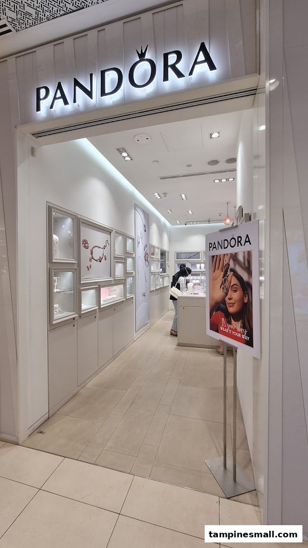 The bright entrance of a Pandora jewelry store, showcasing display cases and a customer browsing.