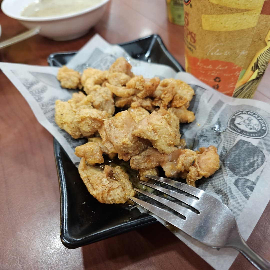 A close-up of crispy fried chicken pieces served on a plate with a fork.