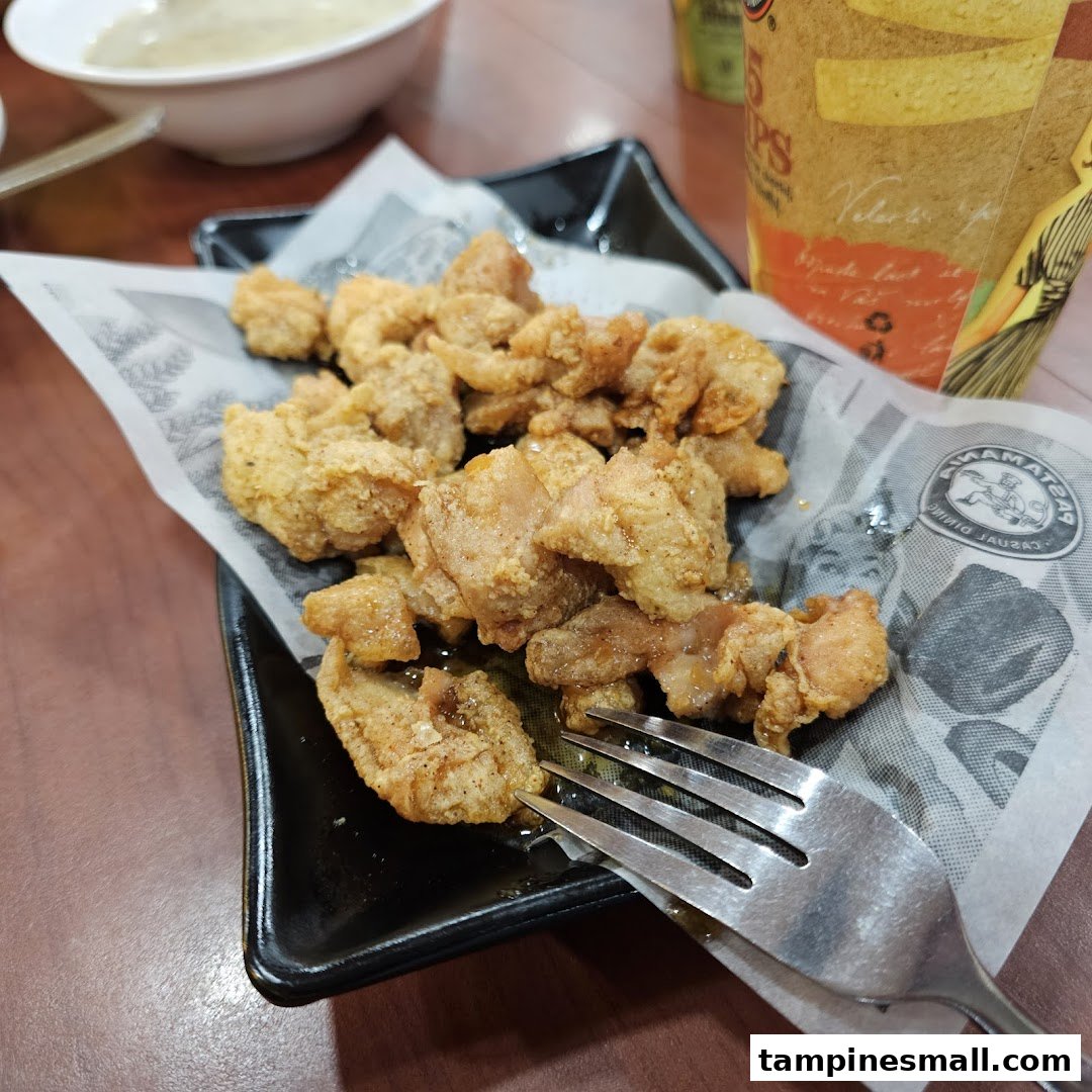 A close-up of crispy fried chicken pieces served on a plate with a fork.