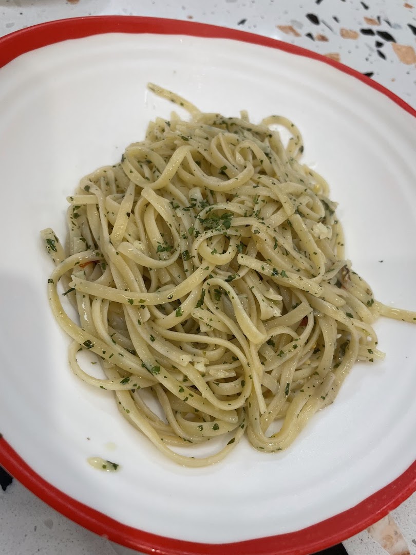 A close-up of a plate of linguine pasta with herbs and garlic.