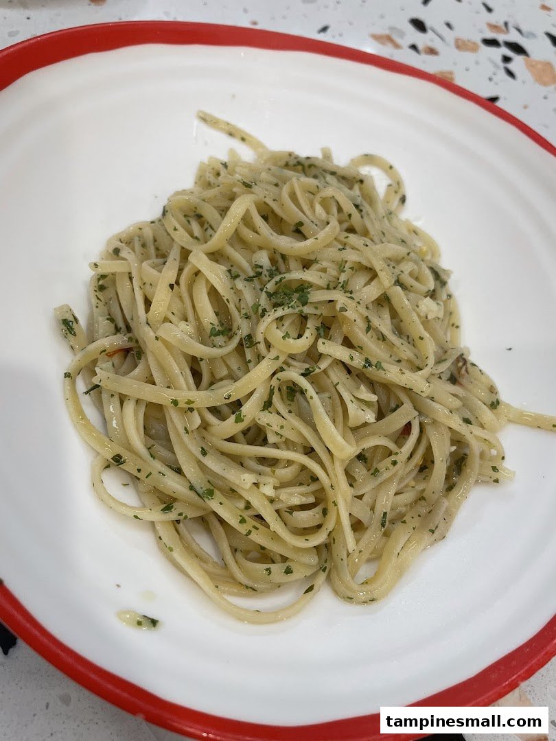 A close-up of a plate of linguine pasta with herbs and garlic.
