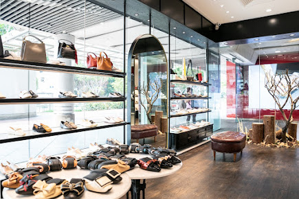 Interior view of PAZZION Tampines Mall, showcasing stylish shoes and handbags on display.