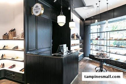 Interior view of PAZZION Tampines Mall, showcasing stylish shoes on display shelves and a central counter.