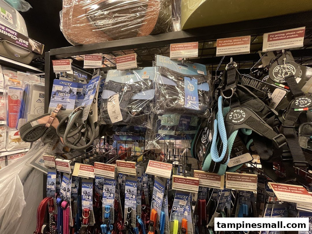 A retail display showcasing a variety of pet harnesses and collars on shelves in a pet store.