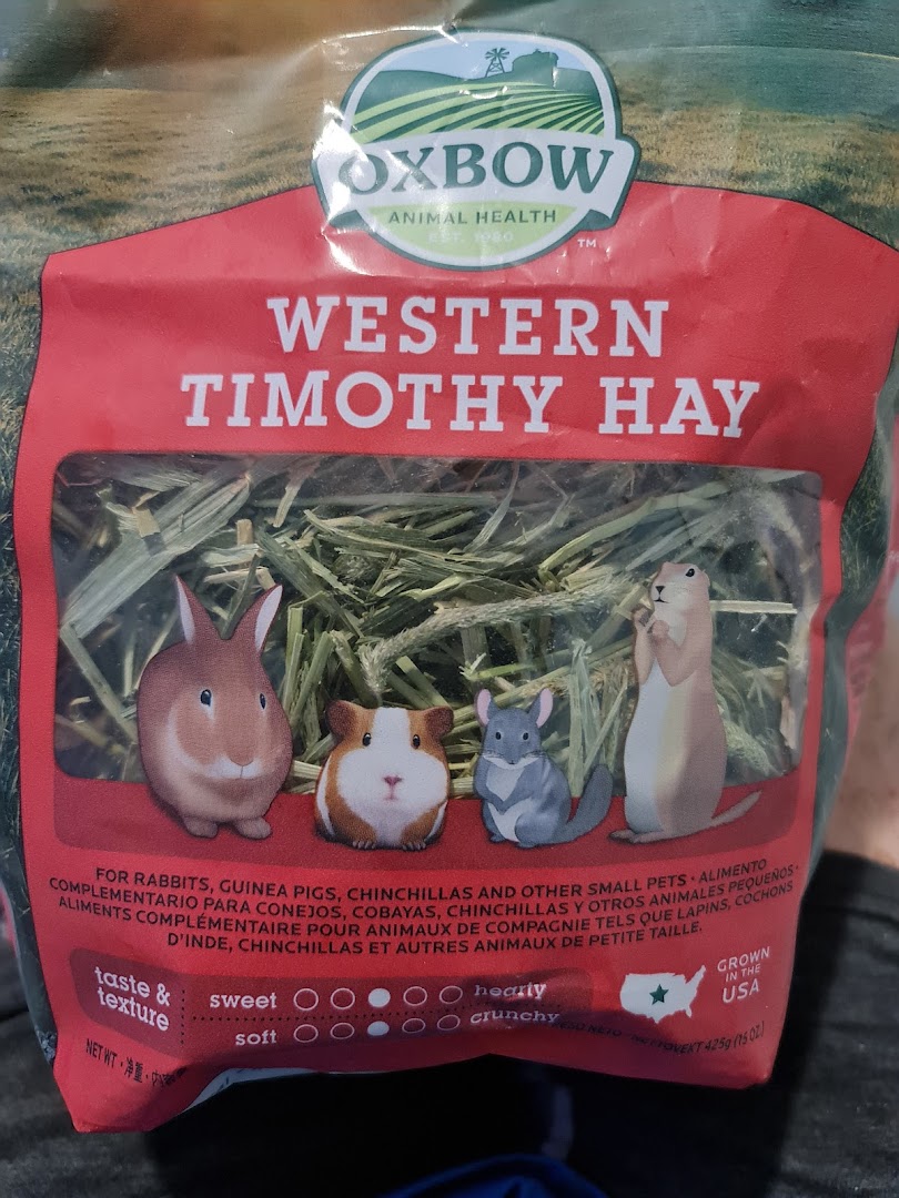 Close-up of Oxbow Western Timothy Hay packaging for small pets, featuring animal illustrations.