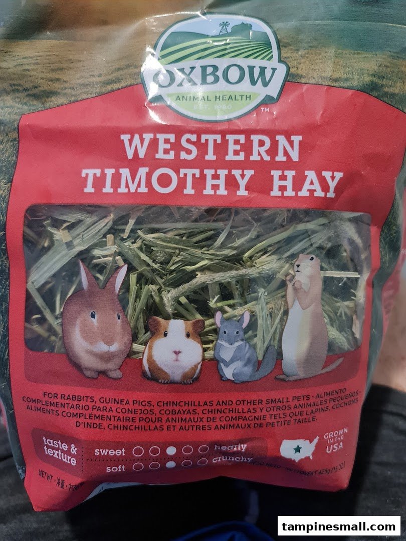 Close-up of Oxbow Western Timothy Hay packaging for small pets, featuring animal illustrations.