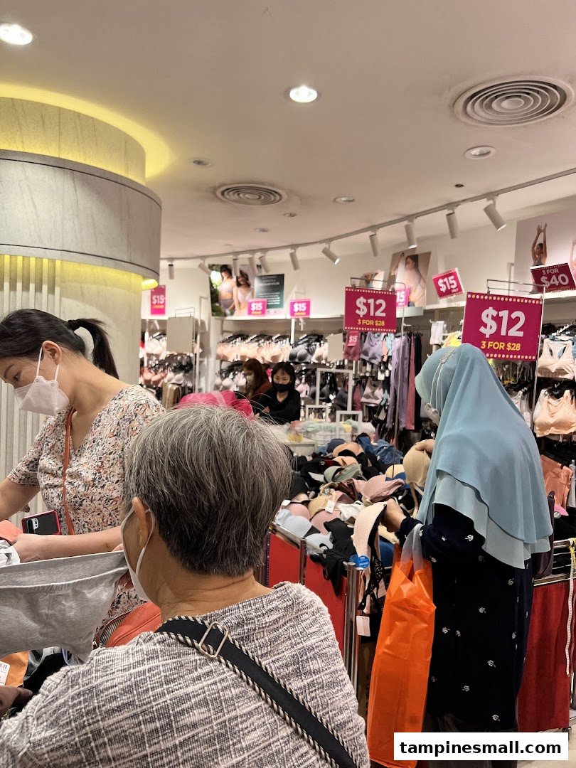 Customers browse a wide selection of lingerie, including bras, with visible promotional pricing.