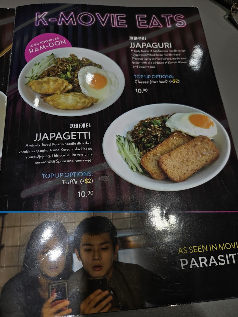 A menu page featuring 'K-MOVIE EATS' with Jjapaguri and Jjapagetti dishes, inspired by Korean cinema.