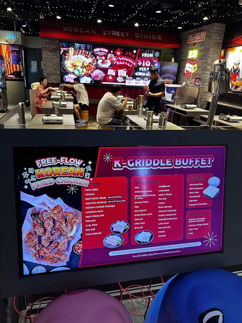 Interior view of POCHA! Korean Street Dining, featuring a digital menu board for K-Griddle Buffet and Free-Flow Fried Chicken.