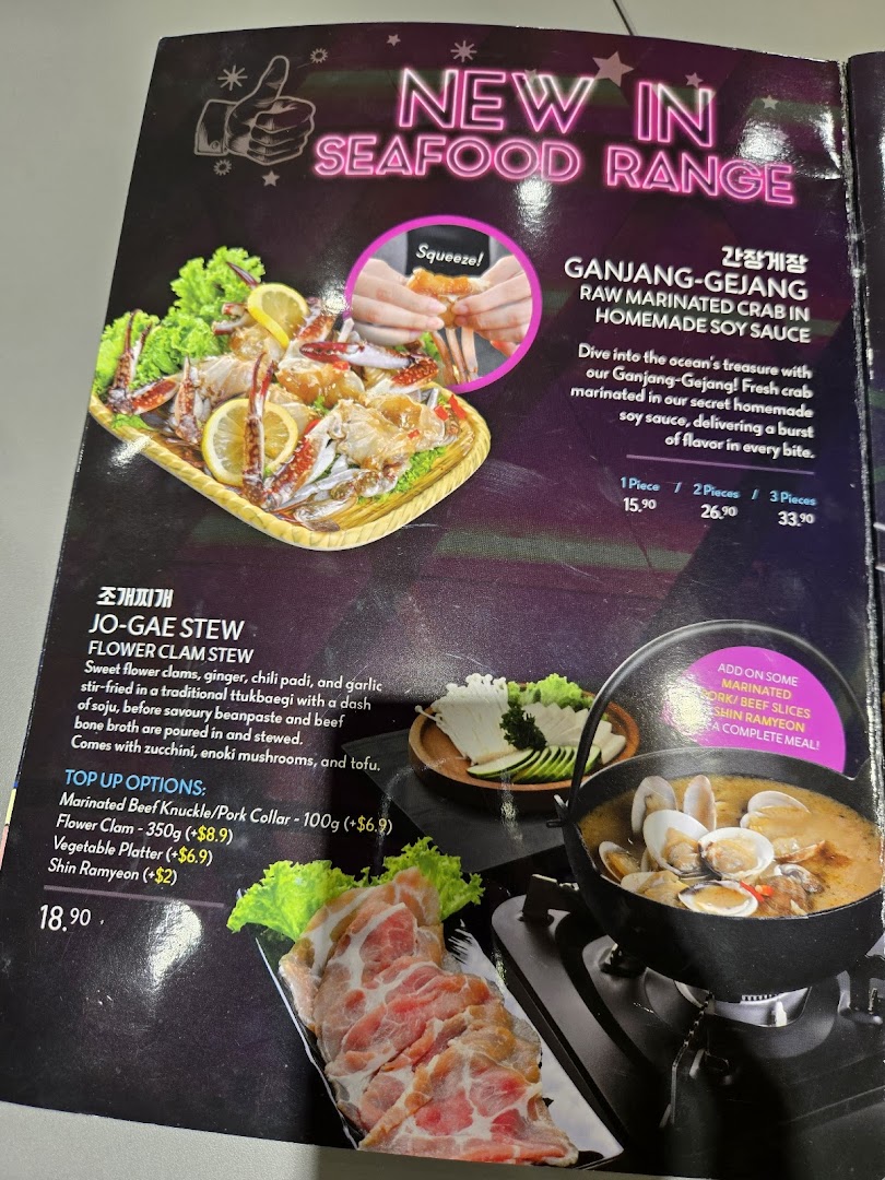 A vibrant menu page showcasing new seafood dishes and a hearty Korean stew with top-up options.