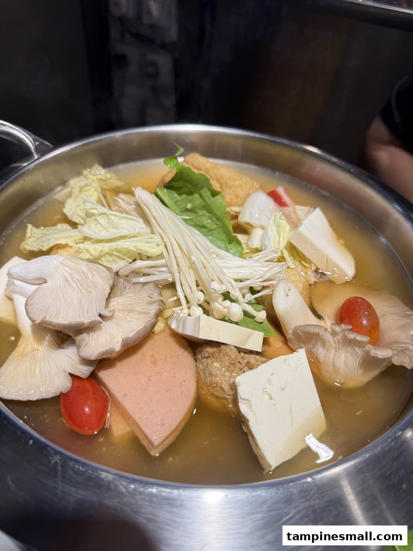 A steaming pot of Korean street food hotpot, brimming with fresh vegetables, mushrooms, tofu, and other delicious ingredients.