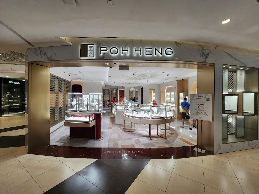 The image shows the brightly lit entrance of Poh Heng Jewellery, displaying various sparkling jewelry pieces in elegant showcases.