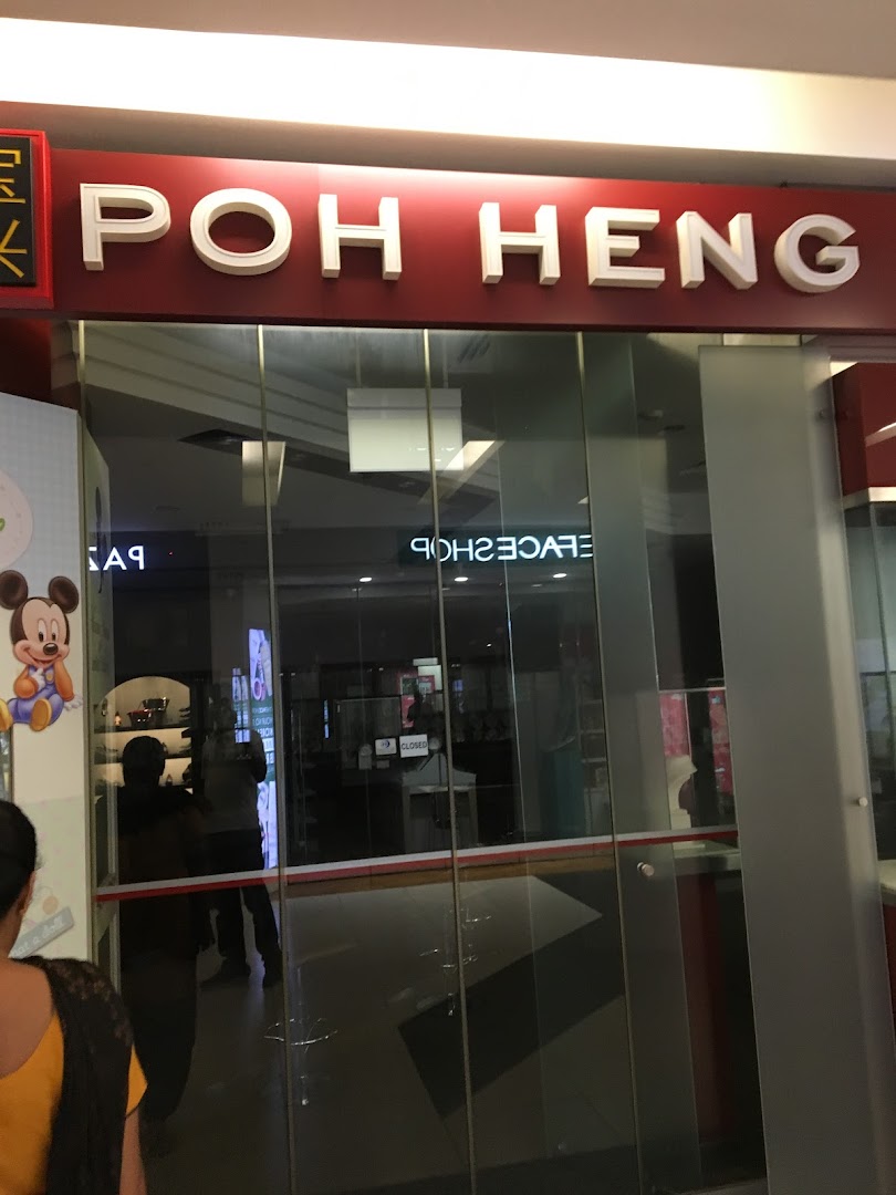 The glass entrance of Poh Heng Jewellery, featuring its prominent red and white signage.
