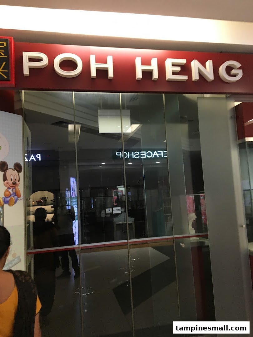The glass entrance of Poh Heng Jewellery, featuring its prominent red and white signage.