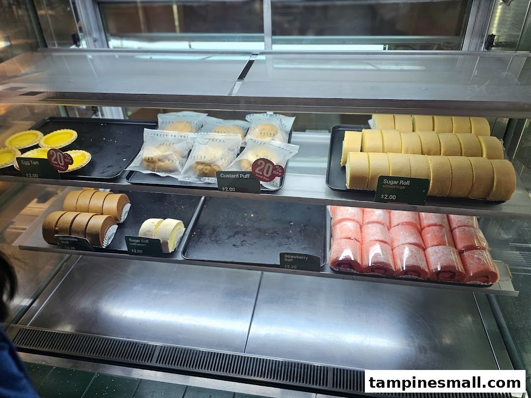 A display case at Polar Puffs & Cakes showcasing a variety of delicious pastries and rolls.