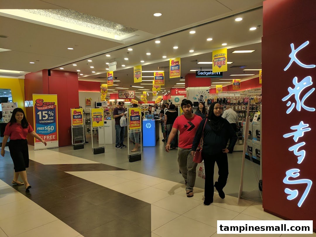 Customers browse books, stationery, and gadgets inside a brightly lit Popular Bookstore.
