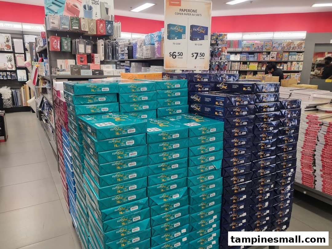 Large stacks of copier paper and stationery items displayed for sale inside a Popular Bookstore.