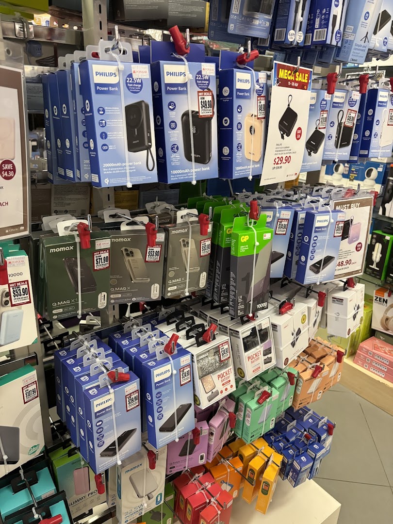 A retail display showcasing various power banks and mobile accessories, including Philips and Momax brands.